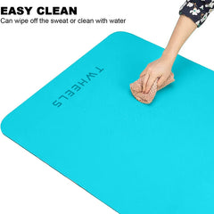 Türkise Yogamatte mit "TWHEELS"-Logo, die von einer Hand mit einem feuchten Tuch gereinigt wird.