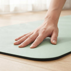 Hand drückt auf die gelenkschonende 6 mm Polsterung der grünen TWHEELS Yogamatte
