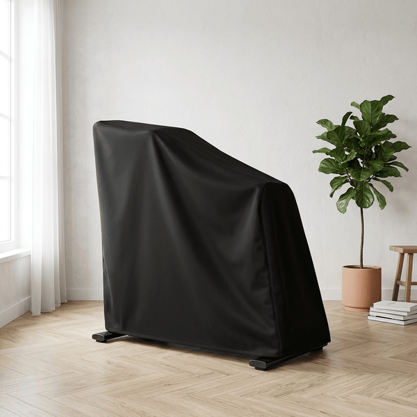 Housse de protection noire TWHEELS sur le vélo d’intérieur dans une pièce de vie lumineuse avec parquet à chevrons