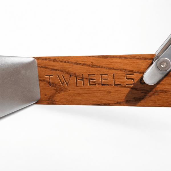 Dettaglio del marchio denominativo TWHEELS inciso nella struttura in quercia rossa della panca per pesi